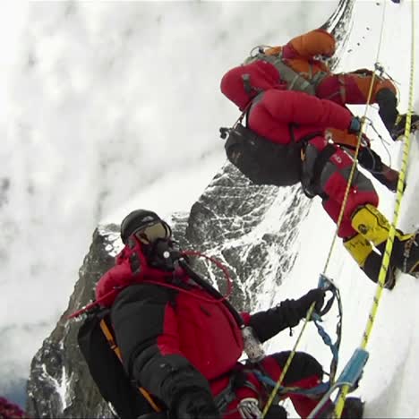 gran fila de escaladores en el monte everest esperando y descansando