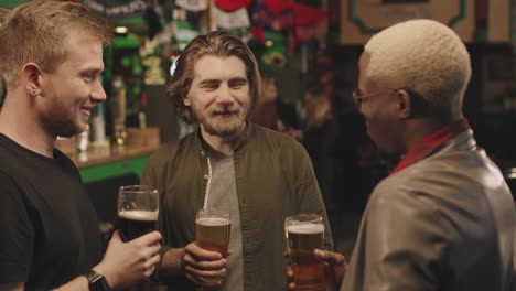 men with beers talking at pub