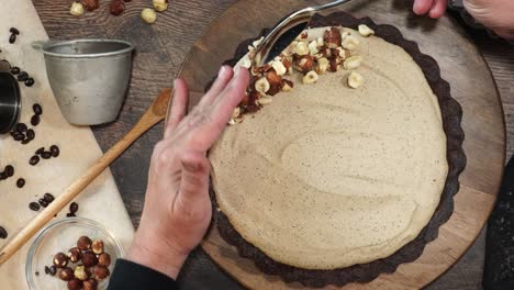 a delicious dessert, coffee hazelnut cream tart. made with espresso powder, chocolate crust and loaded with crushed hazelnut. adding hazelnuts to the top of the pie or tart as a garnish on a table