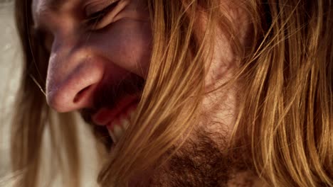 woman strokes man's hair as he smiles at her - close up
