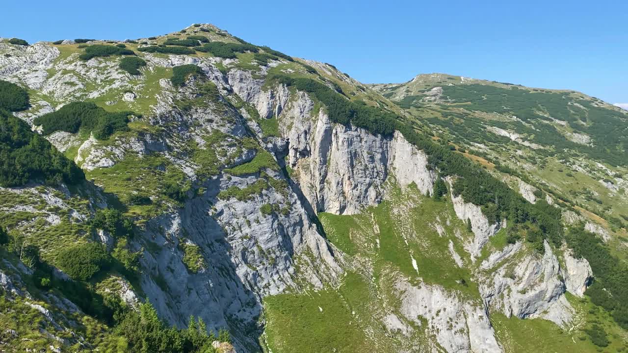 rocas blancas erosionadas de acantilados salpicadas de parches de hierba verde en la ladera de la colina
