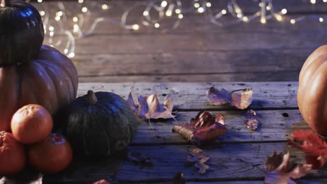 Video-of-halloween-pumpkins-with-leaves-and-copy-space-on-wooden-background