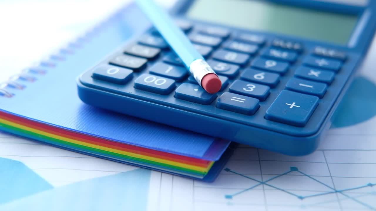 calculadora, lápiz y cuaderno sobre gráficos