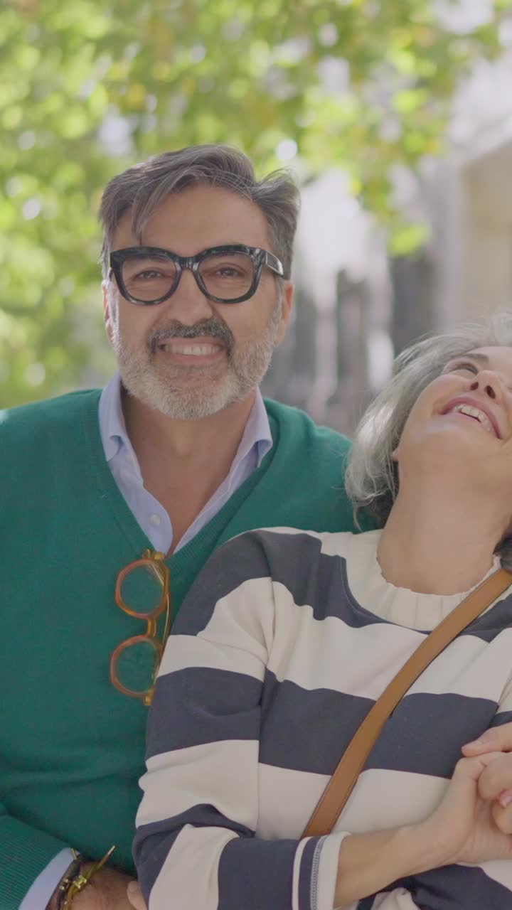 Feliz pareja madura sonriendo y riendo al aire libre