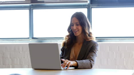 Businesswoman-using-her-laptop-at-work