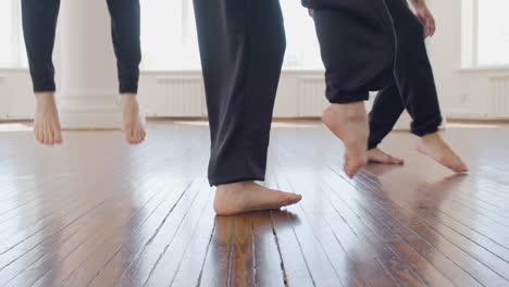 primer plano de las piernas de tres bailarines contemporáneos entrenando movimientos de baile en el estudio 2