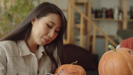 friends write names for their halloween pumpkins