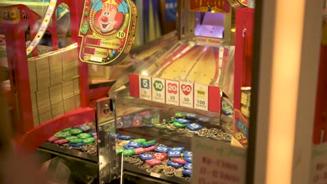 arcade coin pusher, woman pointing at where to drop the coin, slow motion