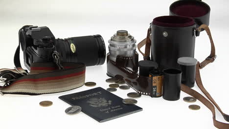 a passport coins camera and equipment sit on a white table