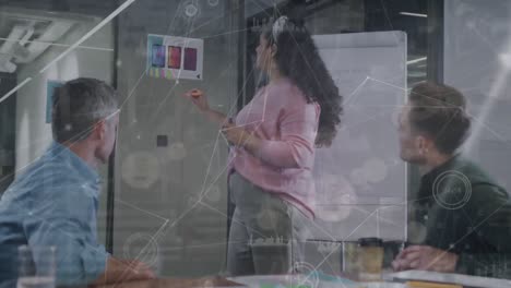 animación de puntos conectados e iconos de gráficos sobre diversos compañeros de trabajo discutiendo ideas sobre un tablero de vidrio