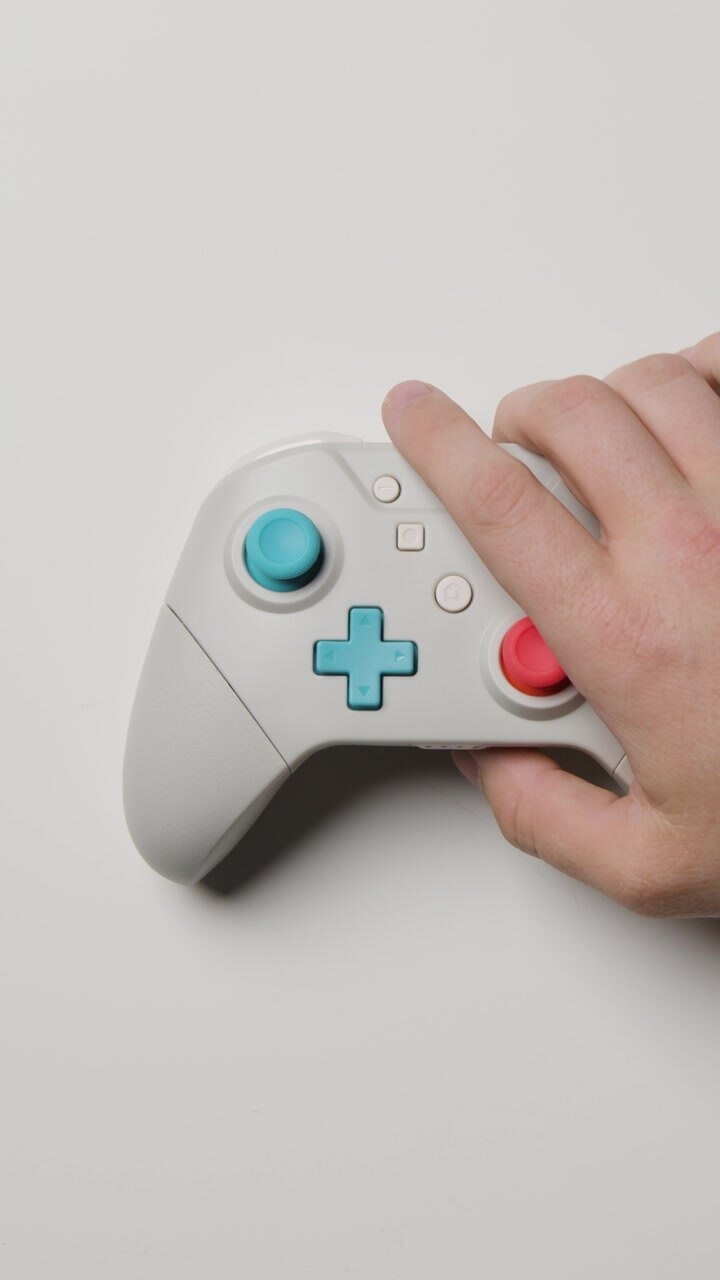 Video verticale: Mano in studio ripresa dall'alto che afferra un controller per videogiochi