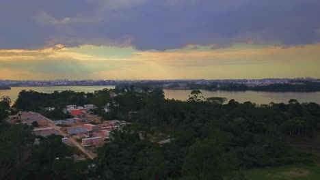 aerial view of the favelas in sao paulo with the city in the background on the horizon