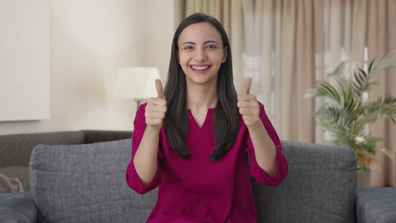 mujer india feliz mostrando los pulgares hacia arriba