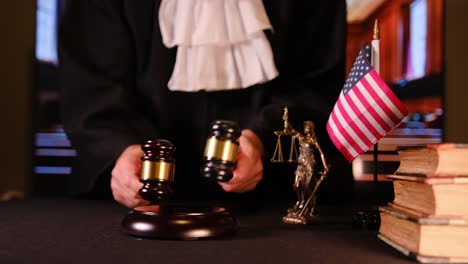 video details of justice, showing gavel, scales and law books in a courtroom