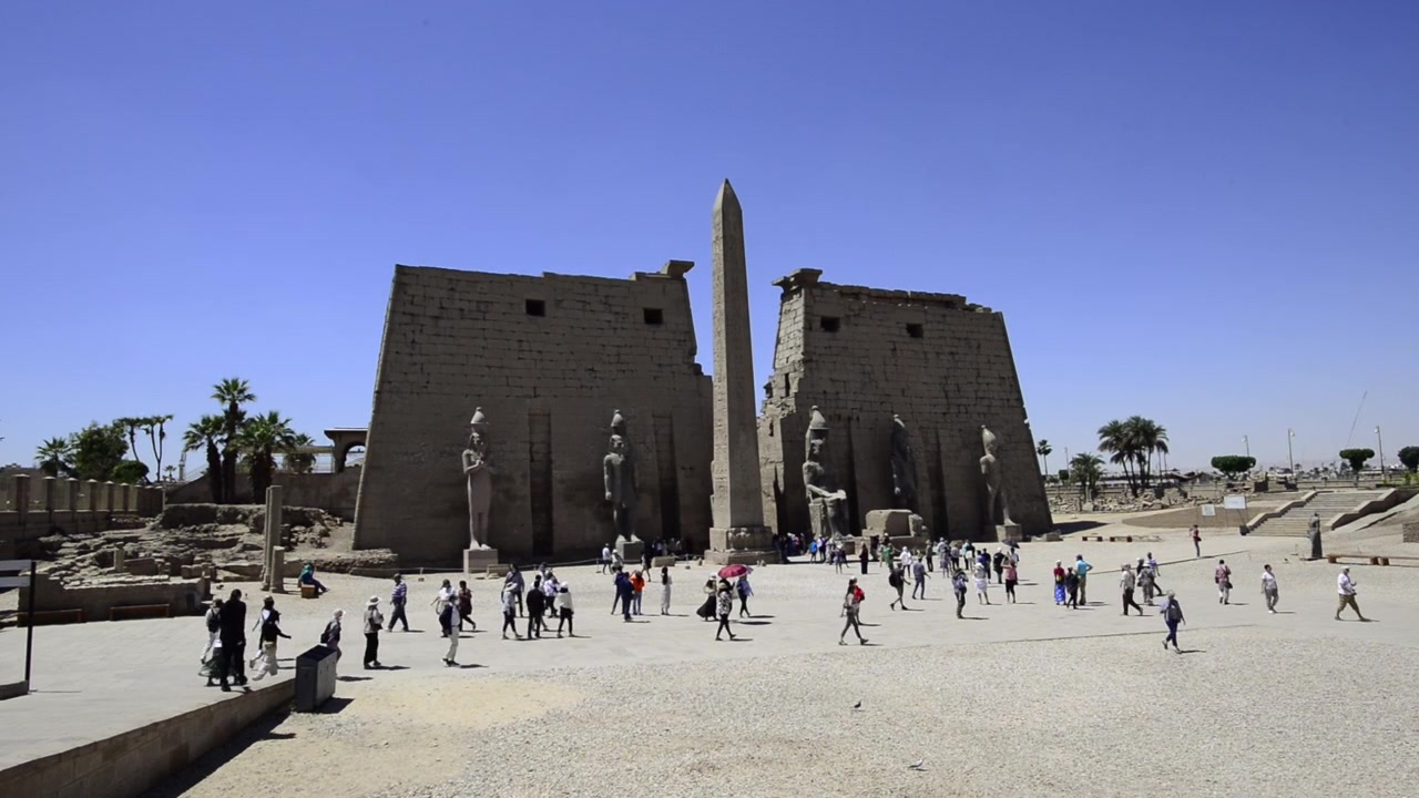 Tempio di Luxor in Egitto, facciata dell'ingresso principale. Molti turisti camminano davanti alla facciata del luogo.