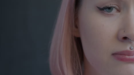 close-up portrait of a woman with pink hair and piercings