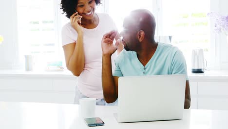 Man-using-laptop-while-woman-talking-on-mobile-phone-4k