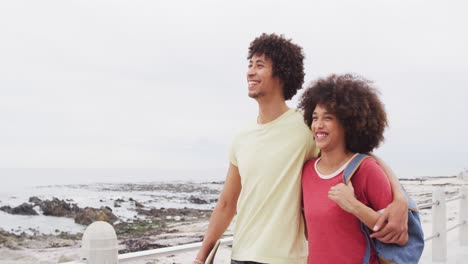 Afroamerikanisches-Junges-Paar-Lächelt-Einander-Zu,-Während-Es-Gemeinsam-Auf-Der-Promenade-Spaziert