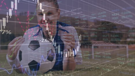 Holding soccer ball, player with financial data animation and stock market graphs