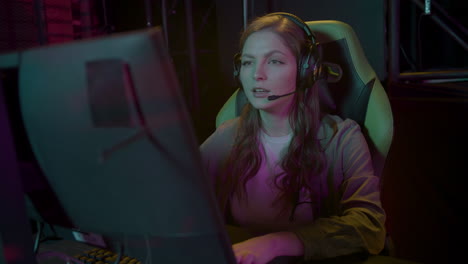 concentrated cybersport female gamer playing video gameswith her friends in a gaming club