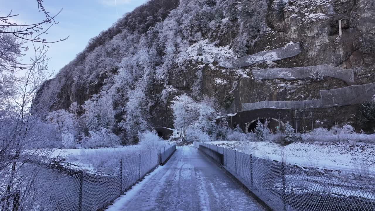 Stunning winter landscape in Walensee, Switzerland, snow-covered bridge leading to scenic alpine tunnel.