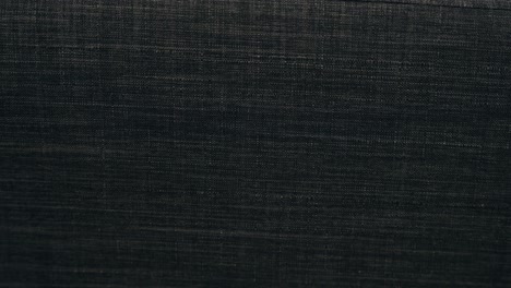 slow pan in background back drop material organic large black grey charcoal threaded polyester cotton wool sofa couch arm texture soft luxurious warm stitched synthetic materials