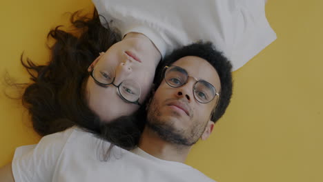 couple lying down on yellow background