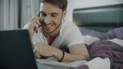 happy man talking on the phone on couch at home