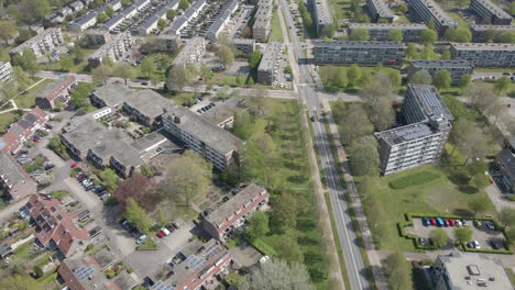 aerial of small suburban neighborhood next to long, calm road