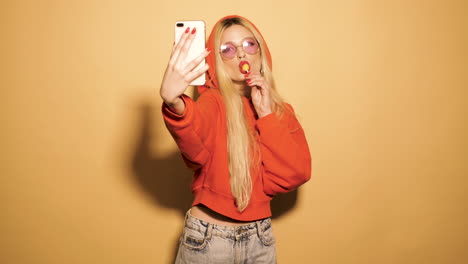 woman taking a selfie with lollipop