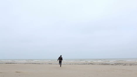 a young man is running to the sea