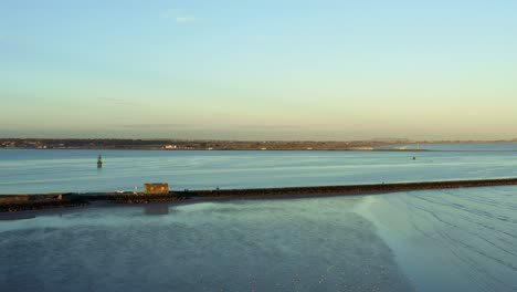 Birds-eye-view-over-the-Great-South-Wall-in-Dublin,-Ireland-during-sunset