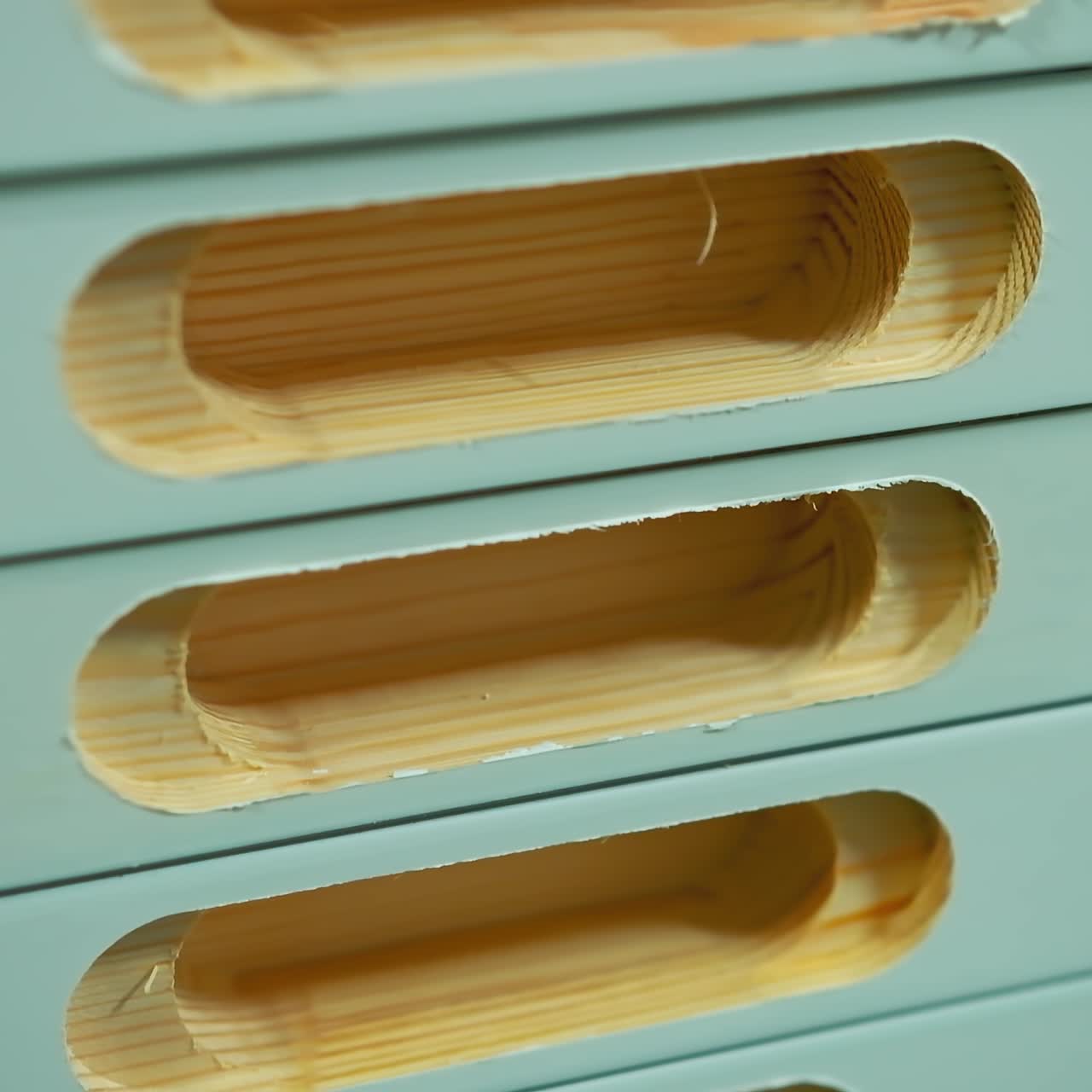 Doors production. Stack of wooden boards with holes inside. Making furniture in the workshop. Close-up.