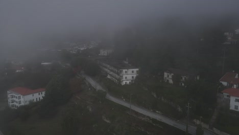 aerial drone view over caramulo sanatorium old abandoned building on misty day, portugal