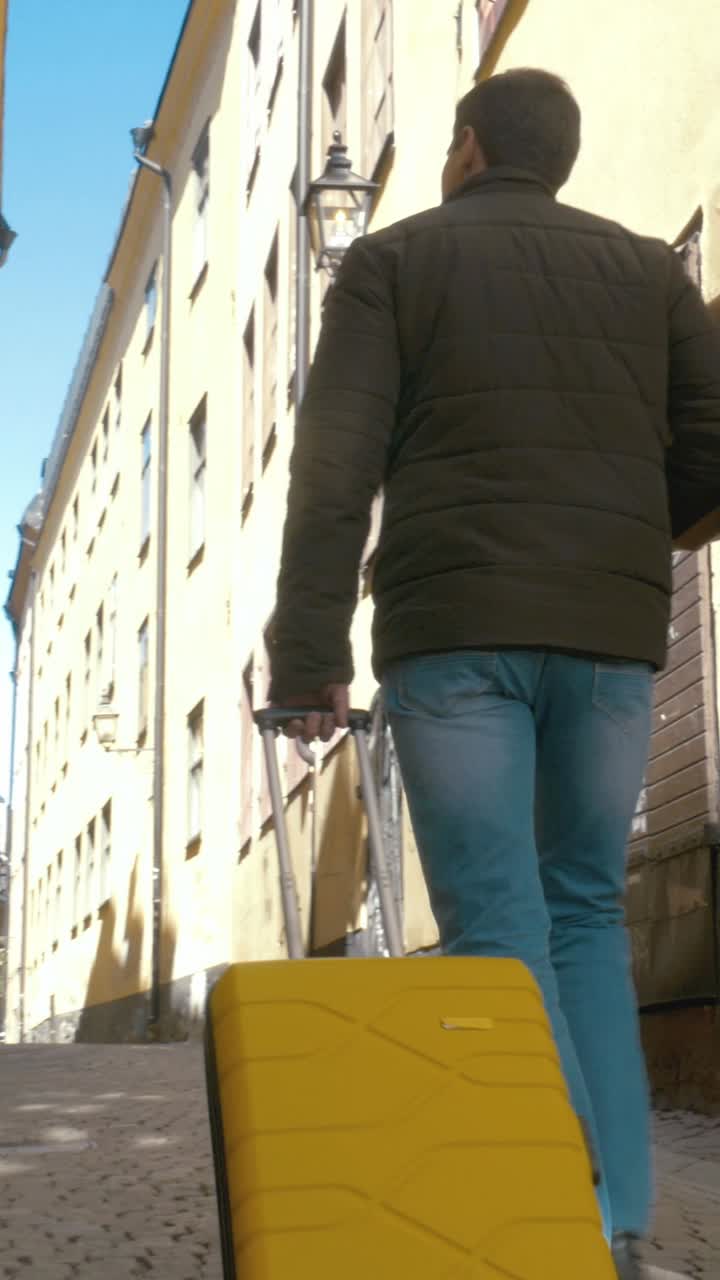 People Walking with Suitcases on a City Street