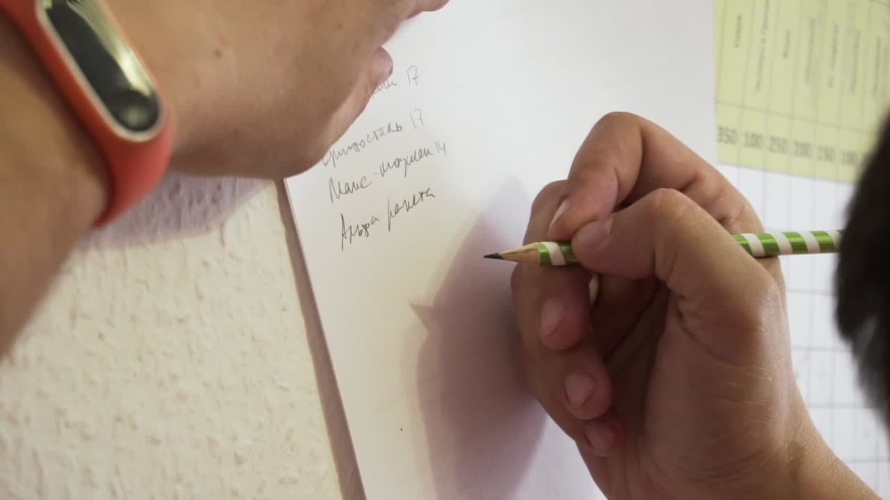 종이에 목록을 쓰는 사람