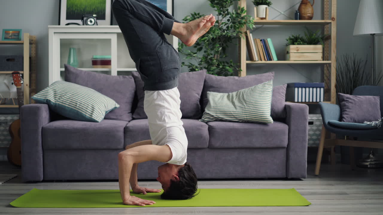 Man Performing Headstand Yoga Pose at Home