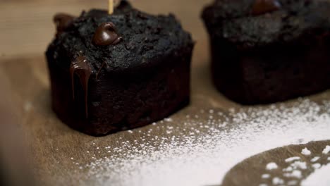 ein schokoladenpulp-rübenmuffin mit geschmolzenen schokoladenchips und zuckerpulver daneben zoomen