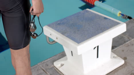 nadador listo para bucear en el bloque de salida de la piscina