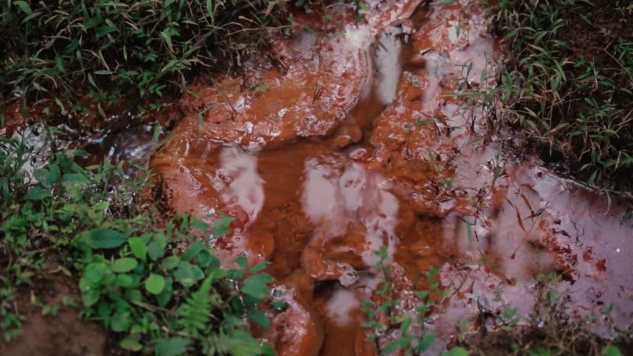 agua que fluye a través del barro y la suciedad en el suelo