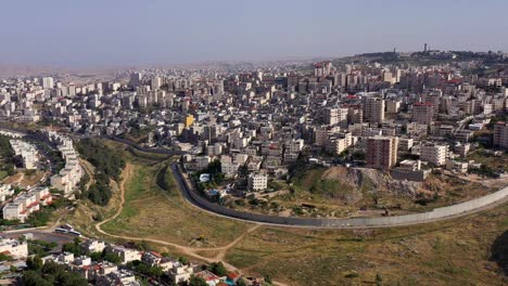 aerial view of a densely populated city with a separation barrier