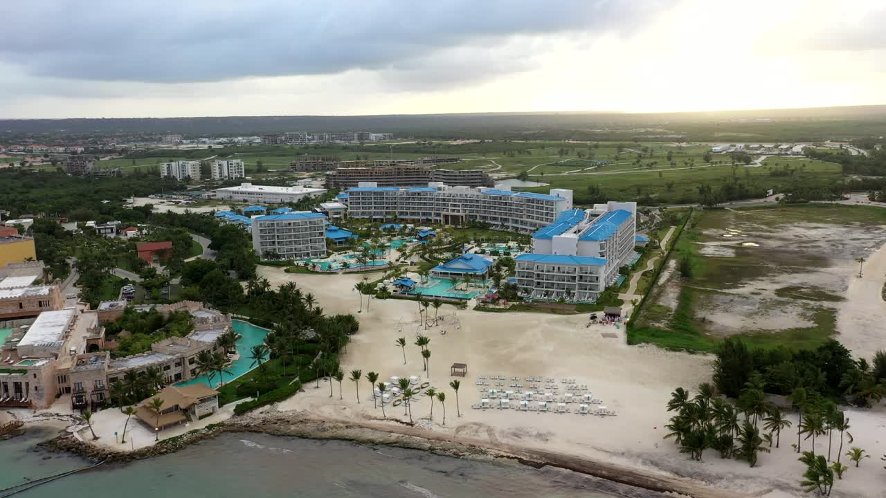High angle drone establishing of Margaritaville Cap Cana resort beside turquoise waters and coastline, Dominican Republic