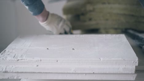 skilled-man-hands-in-gloves-measure-gypsum-plasterboard