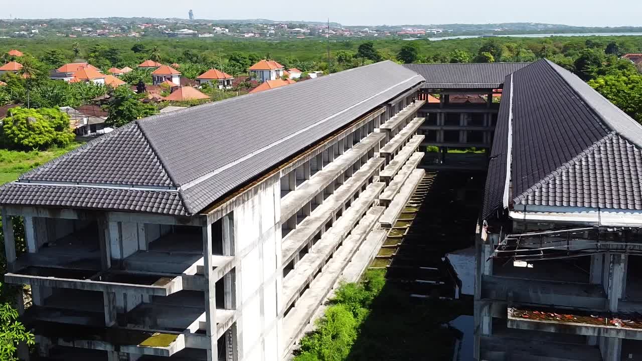 antena - toma rotatoria de drones del frente de un hotel abandonado frente a la playa