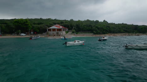 Aerial-side-to-side-dolly-pans-across-boats-anchored-offshore-of-Croatia-on-stormy-day