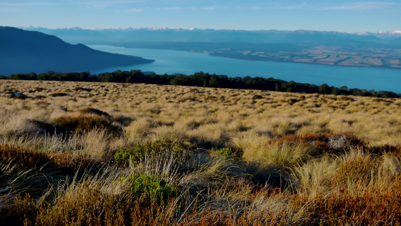 maravilloso paisaje con campo de hierba de dunas y hermoso lago azul con montañas en segundo plano