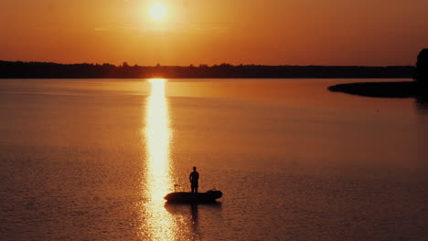 toma aérea de hombres pescando desde el barco frente al sol brillante por la noche