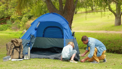 father and son preparing their tent