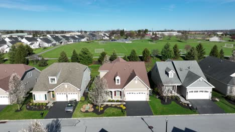 a side track aerial shot of a residential area with a soccer field in the background at the usa