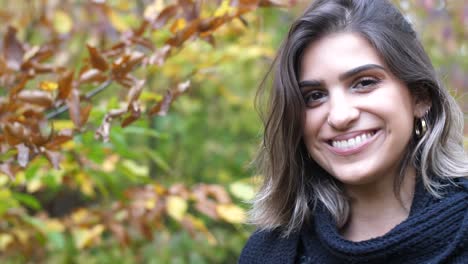 primer plano de una chica morena en el bosque de otoño, se ríe dulce de la cámara